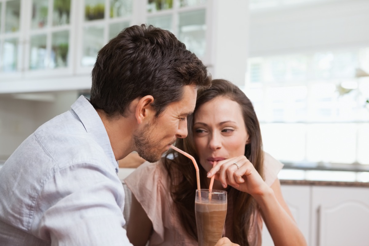 Close-up of a loving young couple sharing a drink at home