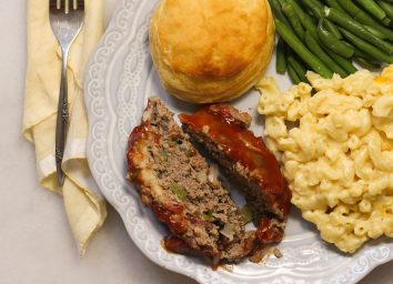 Slices of meatloaf on a plate with sides.
