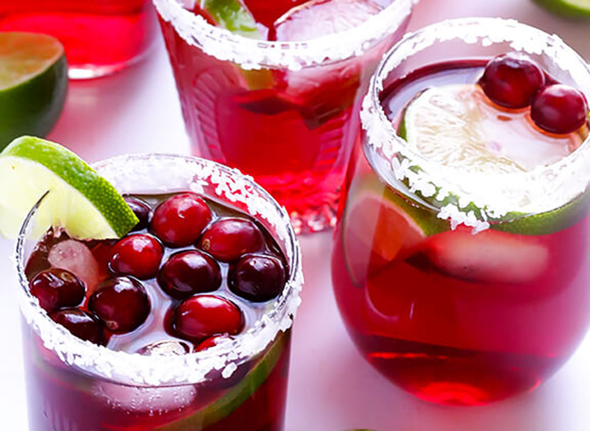 glasses of cranberry margaritas with lime slices and salt on rim