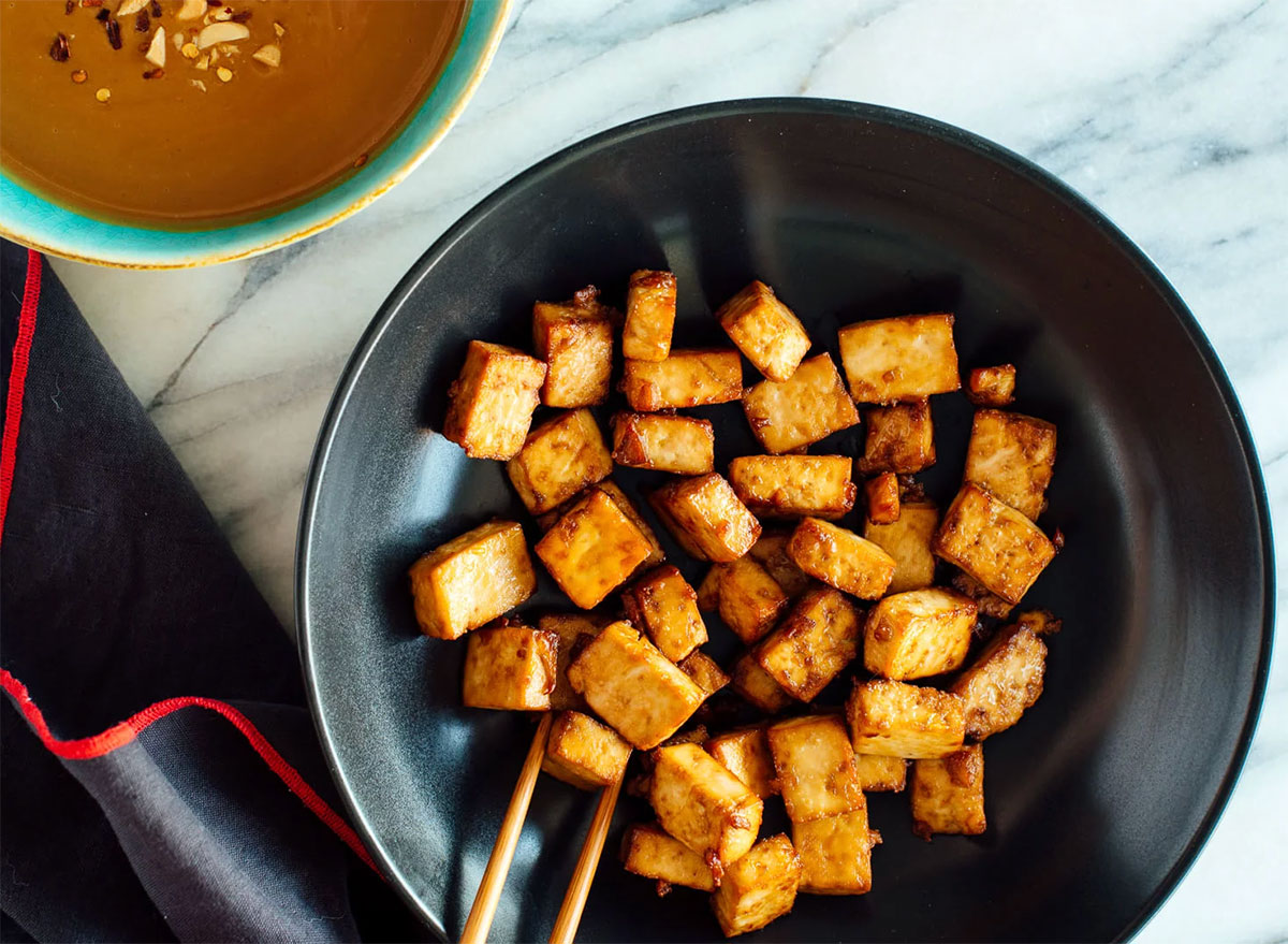 crispy tofu bites in bowl with chopsticks