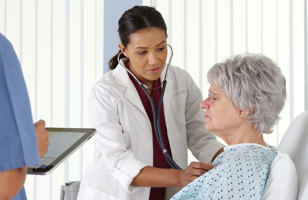 doctor listening to elderly patient's heart with stethoscope