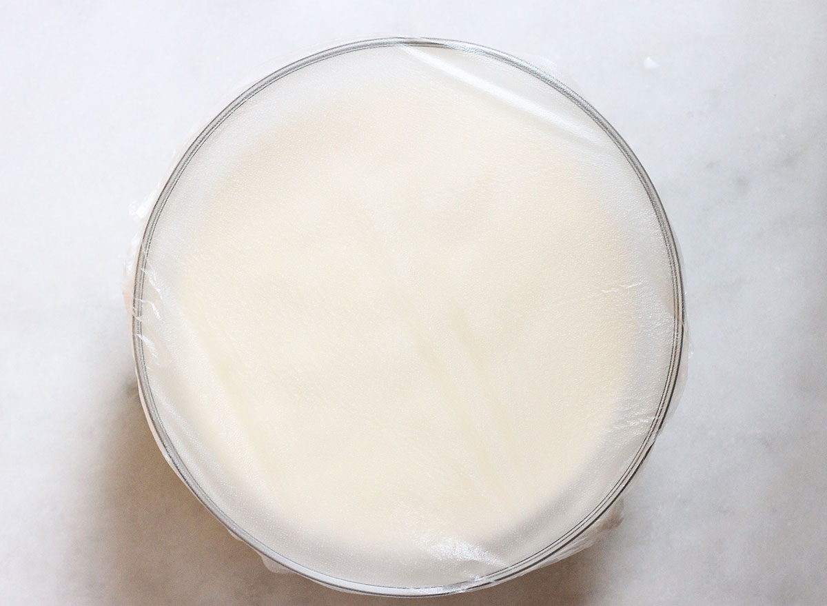 covering eggnog mixture in a bowl with plastic wrap