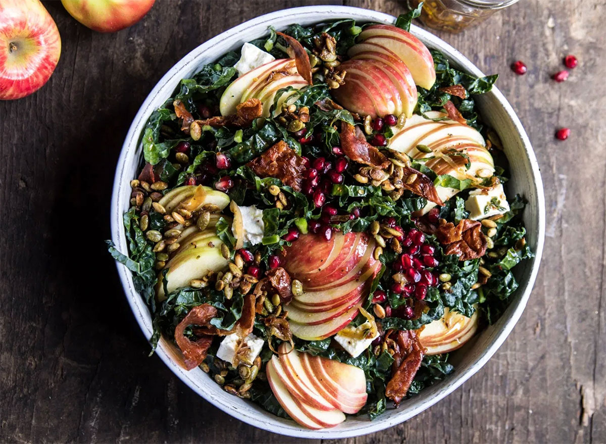 bowl of kale salad with honeycrisp apples and pomegranate seeds