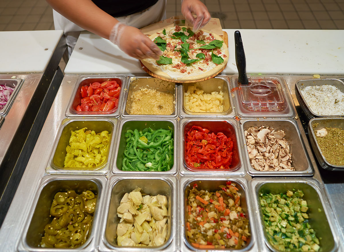 Serve making customized pizza at a fast casual restaurant