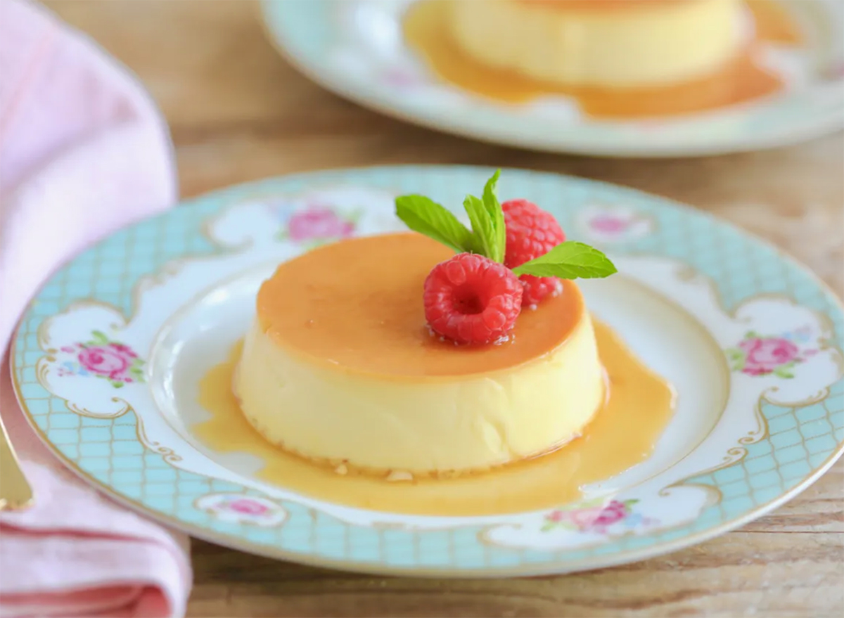 individual serving of flan topped with raspberry on plate