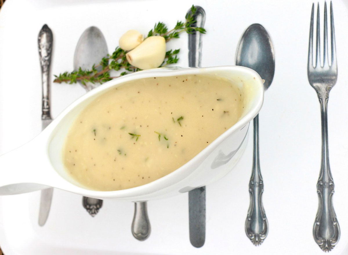 boat of gravy on top of flatware setting