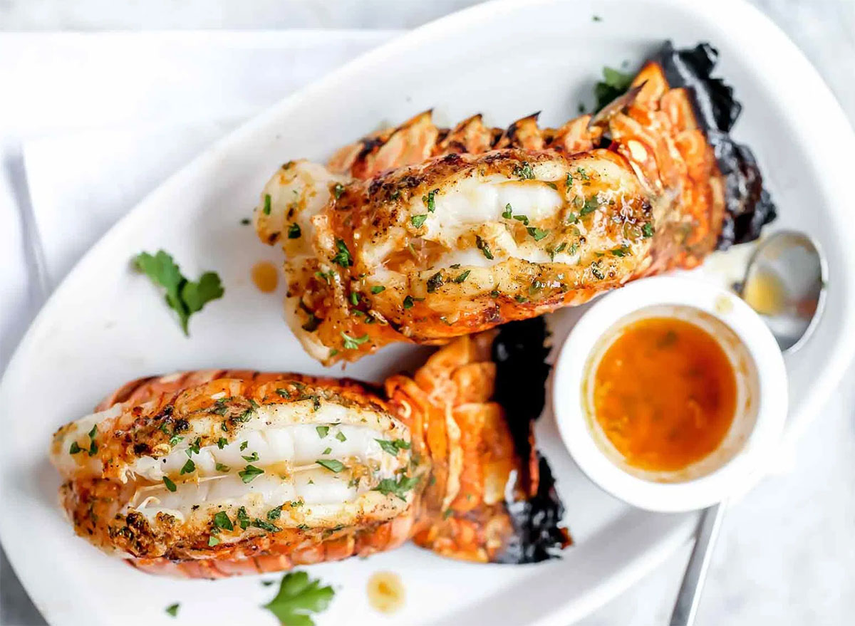 two whole grilled lobster tails with paprika butter and parsley