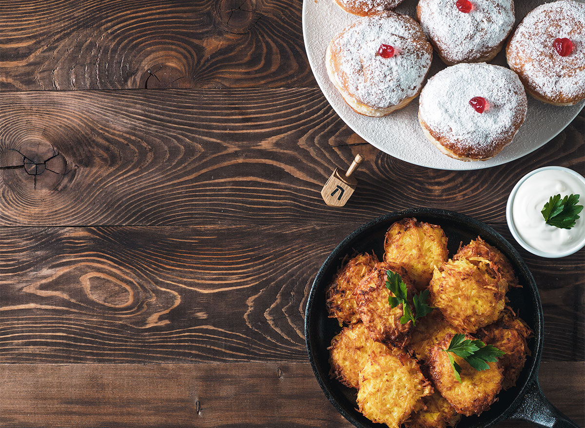 jelly donuts and latkes with dreidel on table