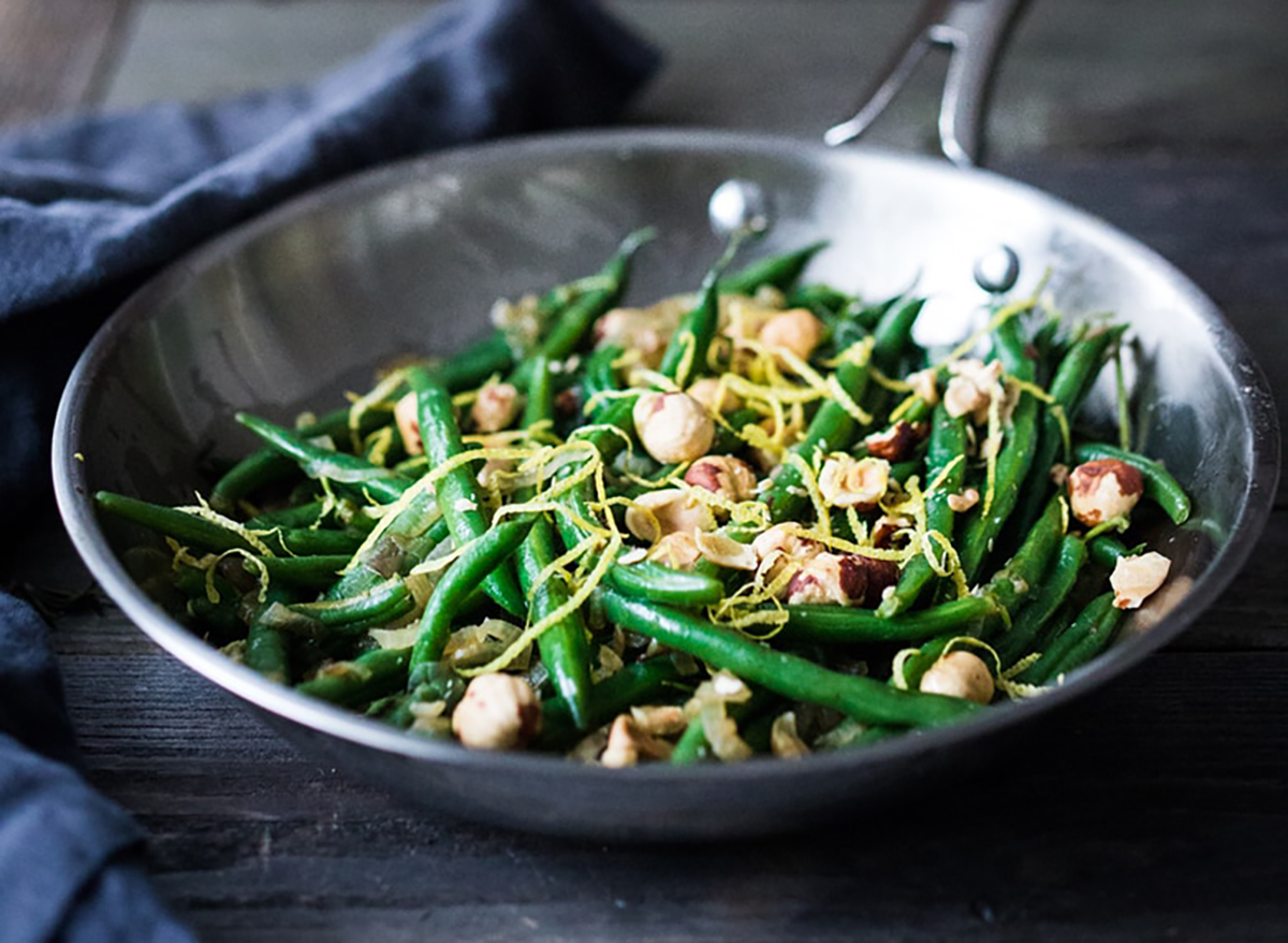 green beans with hazelnuts and lemon zest in pan