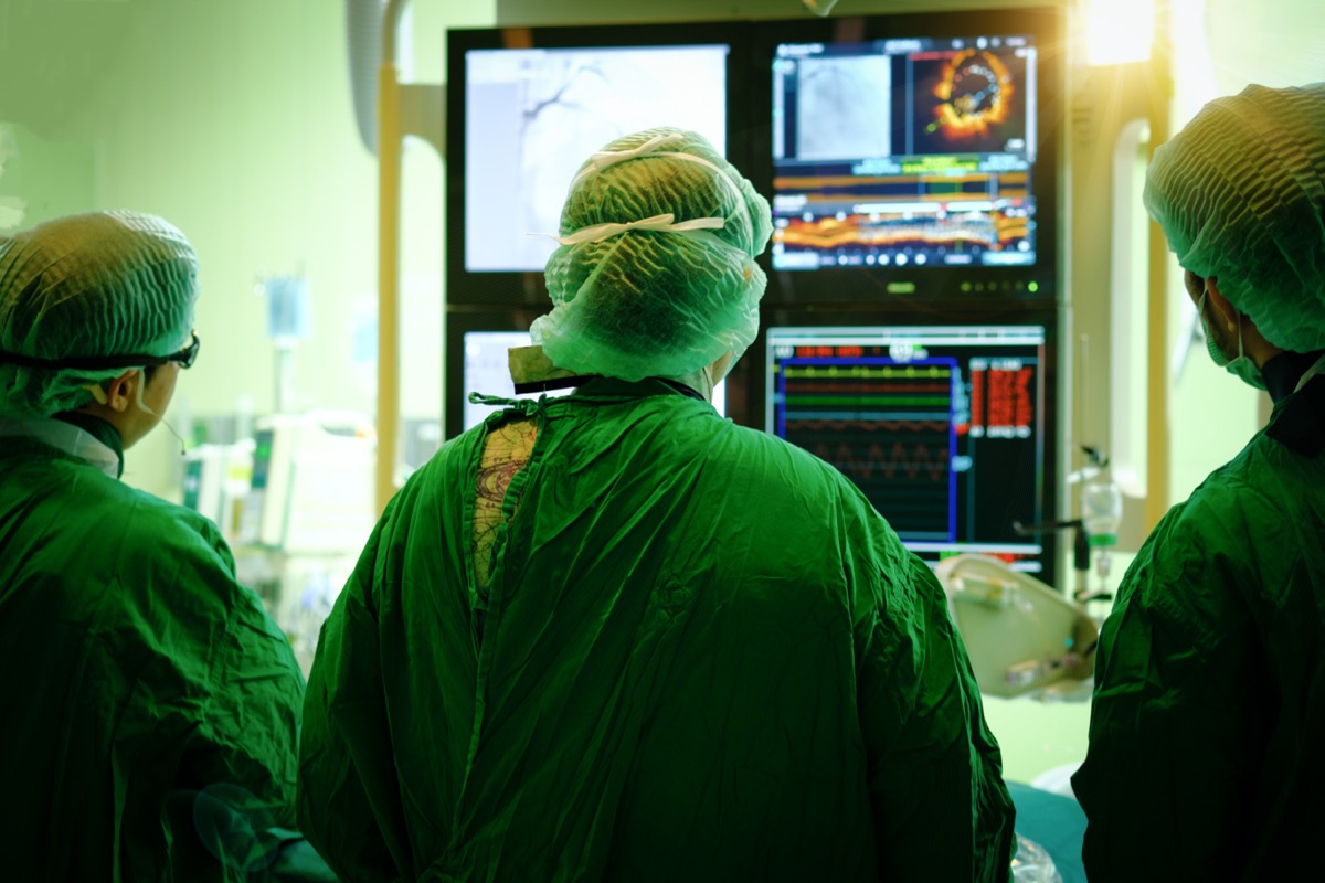Interventional cardiology. Male surgeon doctor with coronary monitor in operating room