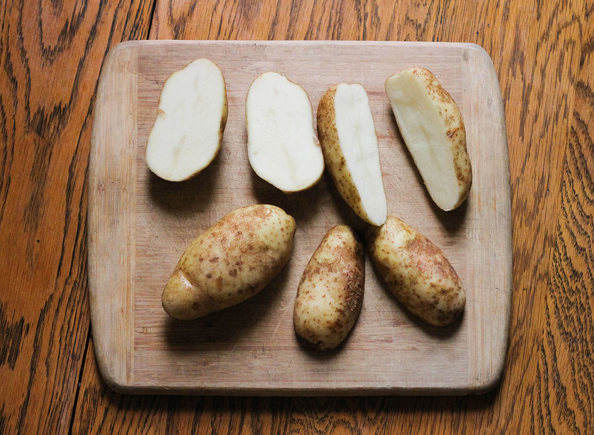 Potatoes cut in half on a cutting board