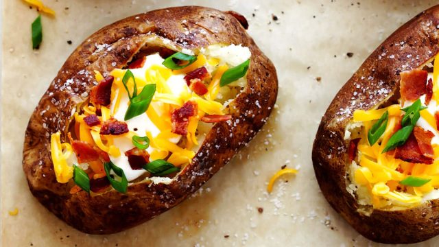 loaded baked potatoes on parchment paper with salt