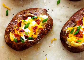 loaded baked potatoes on parchment paper with salt