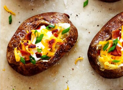 loaded baked potatoes on parchment paper with salt