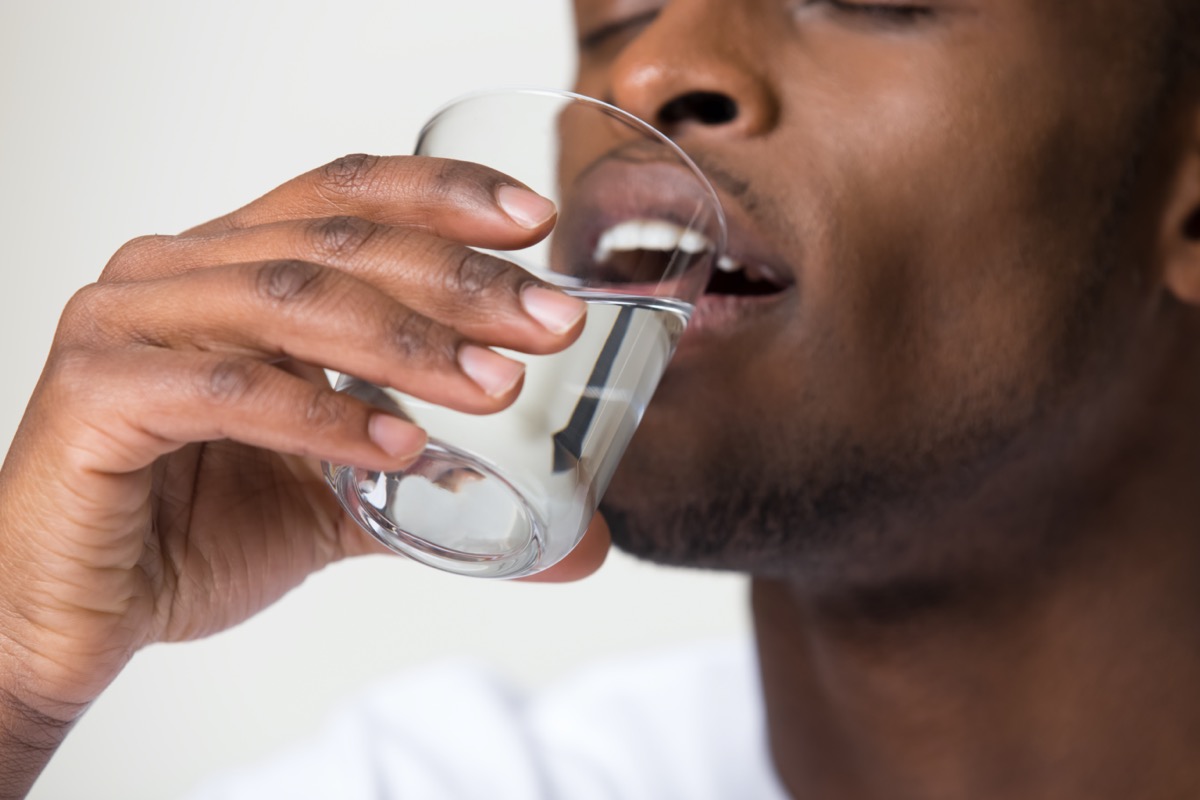 man holding glass drinking water