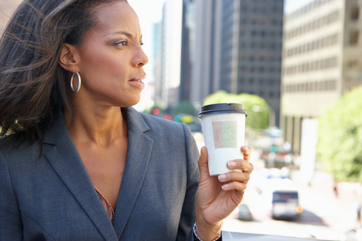 Businesswoman Drinking Takeaway Coffee Outside Office