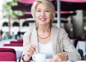mature female who is enjoying of lunch with coffee in cafe