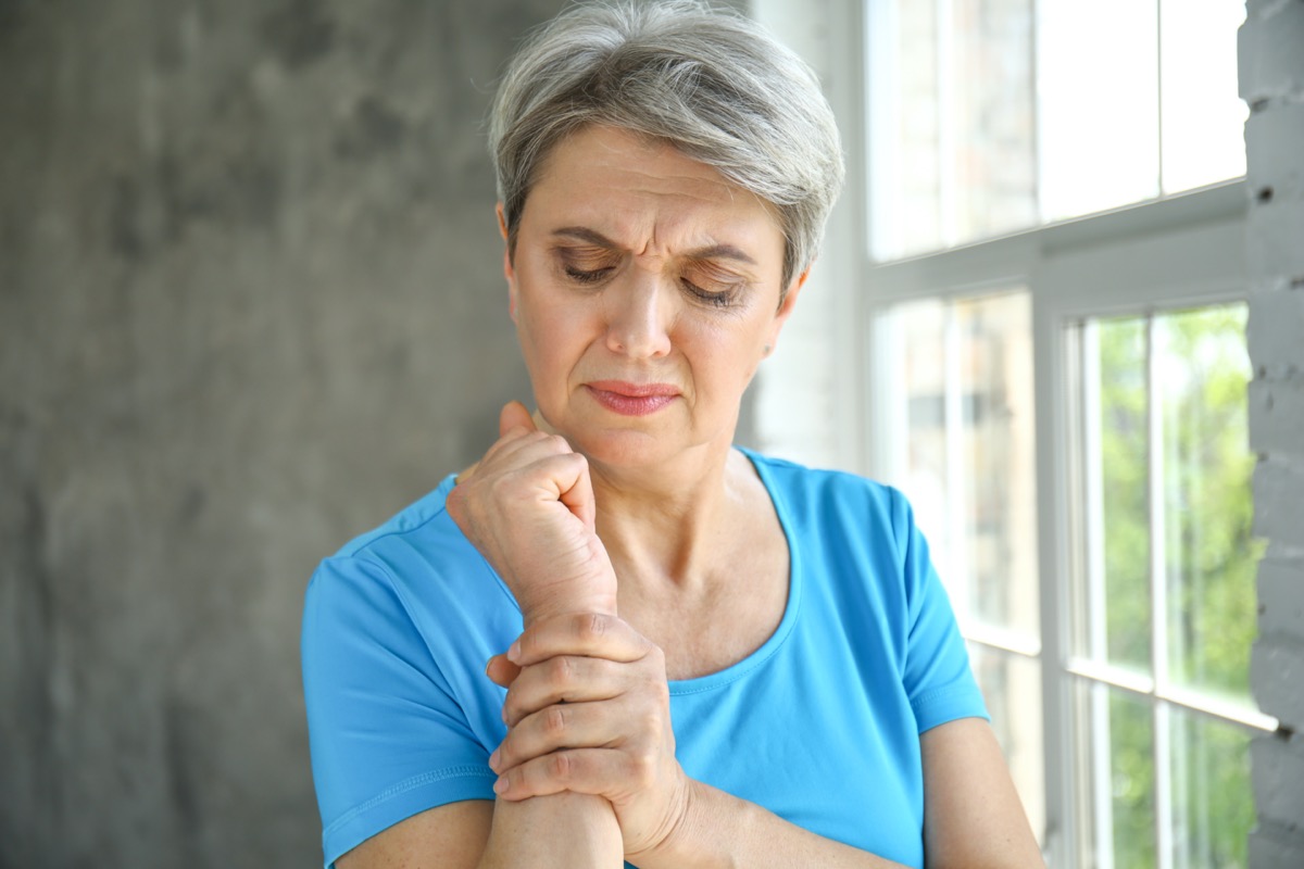 Mature woman suffering from pain in wrist at home