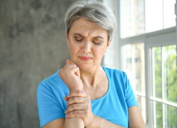 Mature woman suffering from pain in wrist at home
