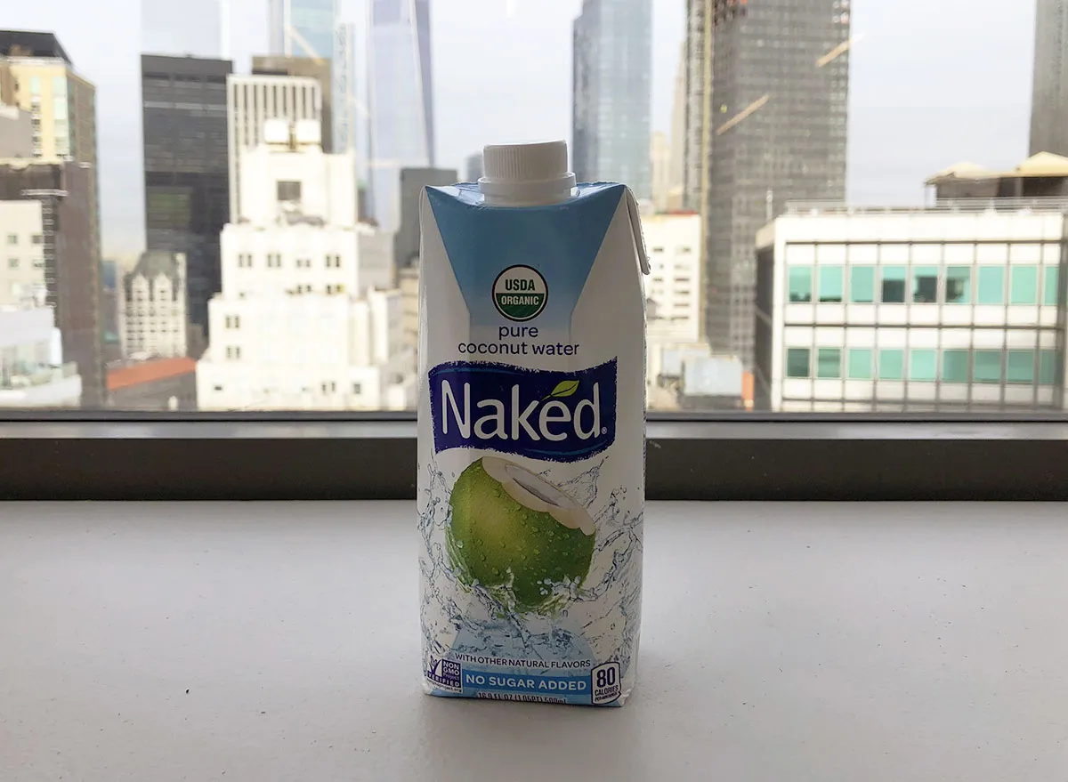 naked pure coconut water bottle by window