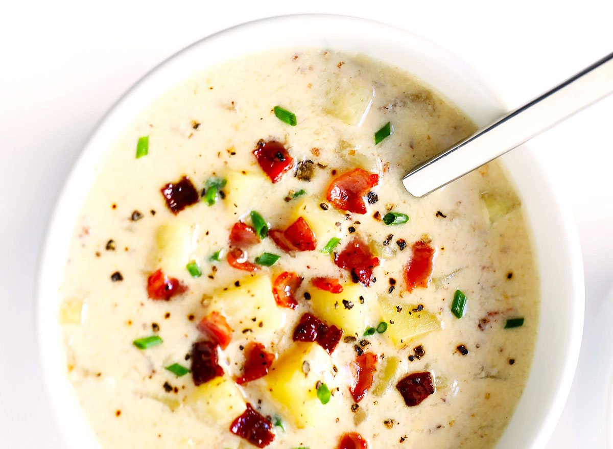 bowl of new england clam chowder topped with bacon