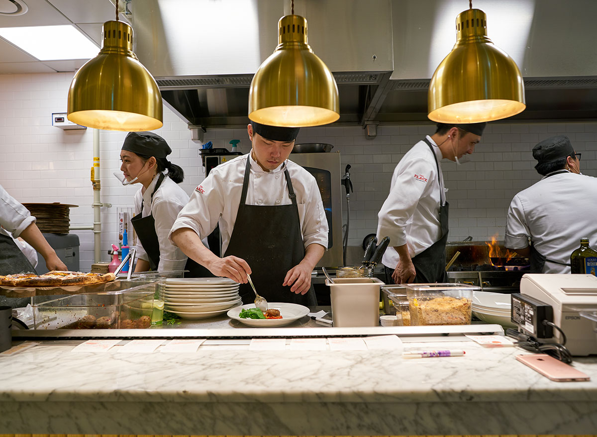 Chef making a dish in an open kitchen