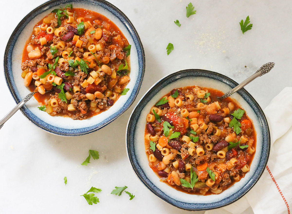 Two bowls of copycat Olive Garden pasta fagioli with parsley and parmesan cheese