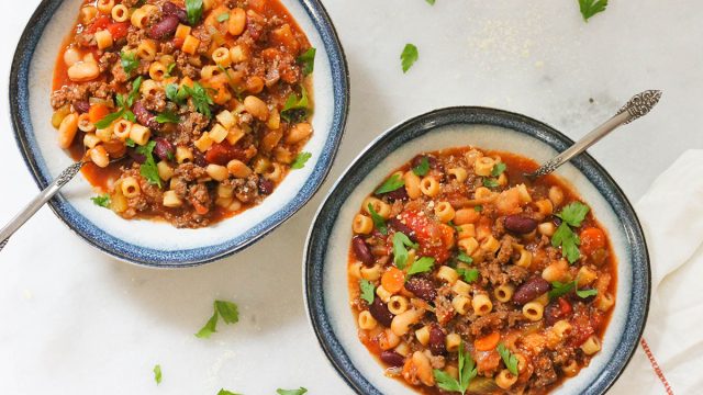 Two bowls of copycat Olive Garden pasta fagioli with parsley and parmesan cheese
