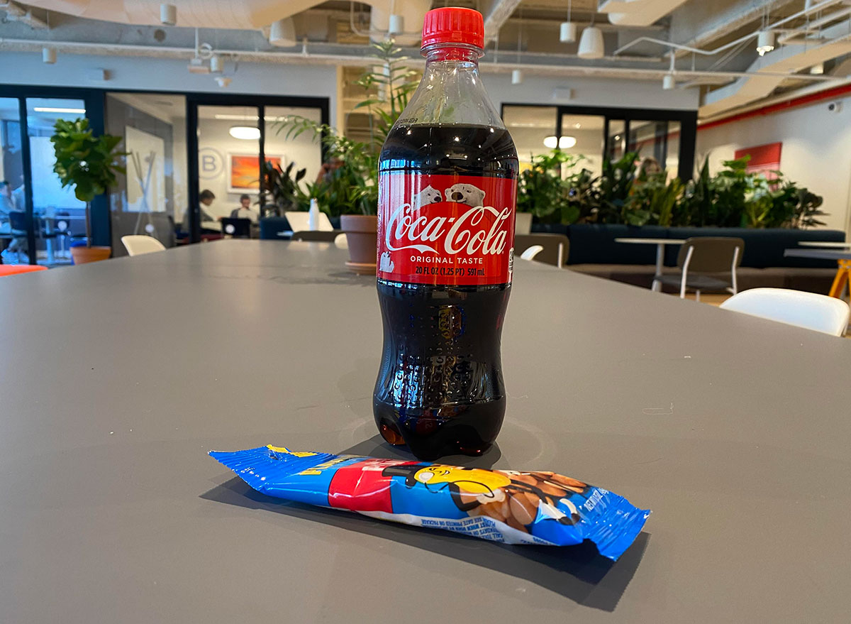 bottle of coke and bag of peanuts on table