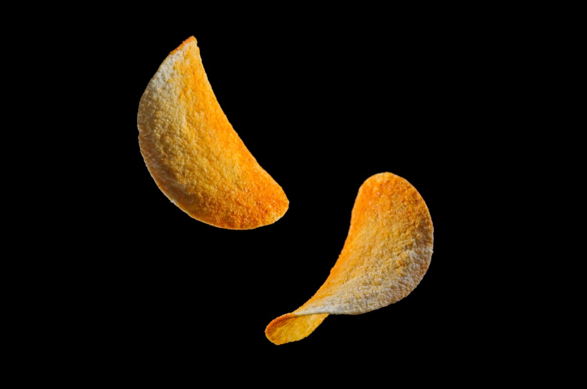 free-floating pringles against a black background