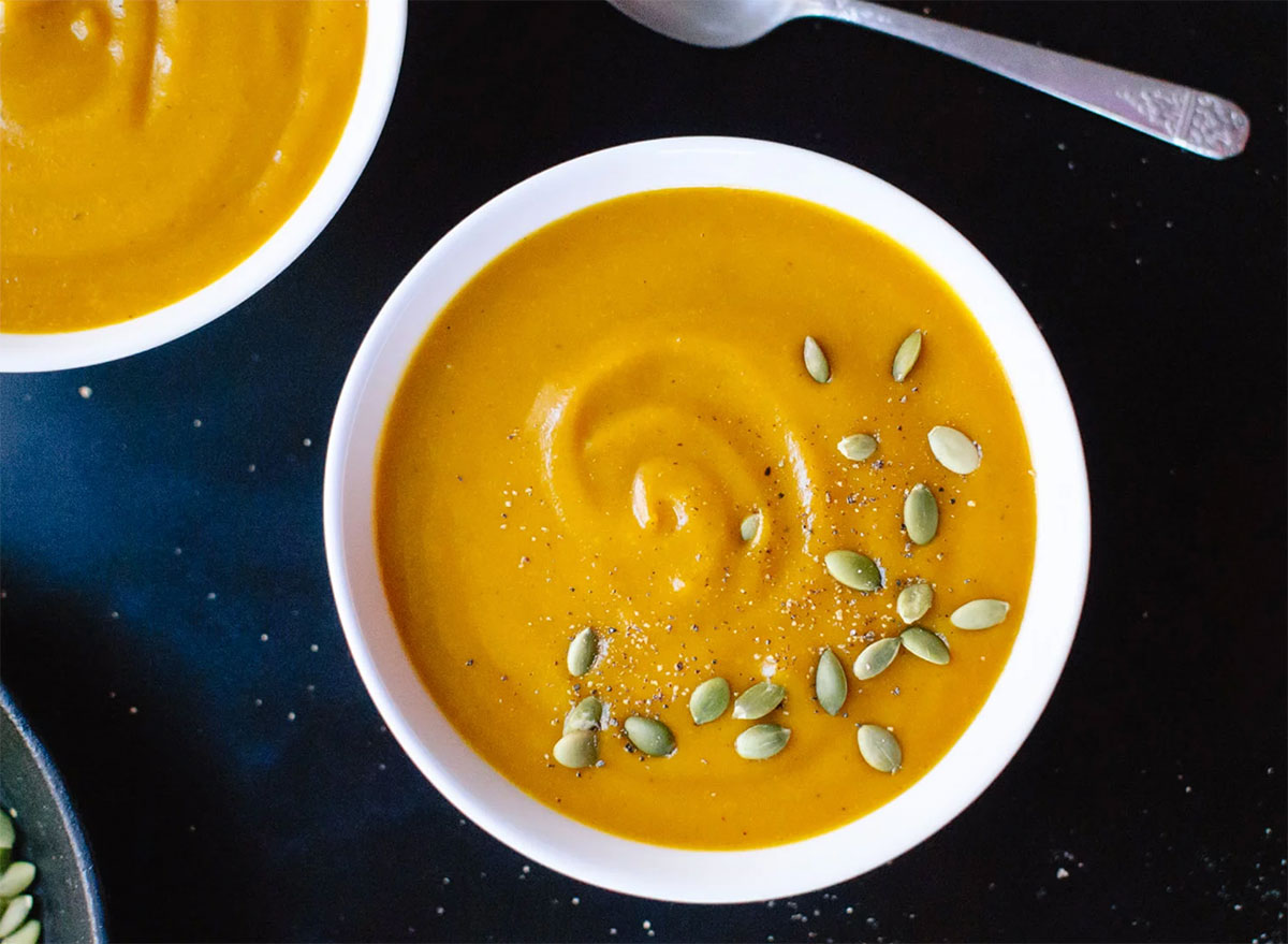pumpkin soup with roasted pumpkin seeds in white bowl