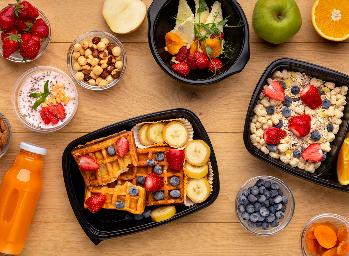 containers of ready made breakfast with strawberries blueberries waffles oatmeal chia pudding