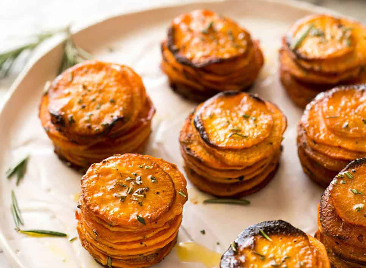 roasted sweet potato stacks of sliced potatoes on baking sheet with rosemary