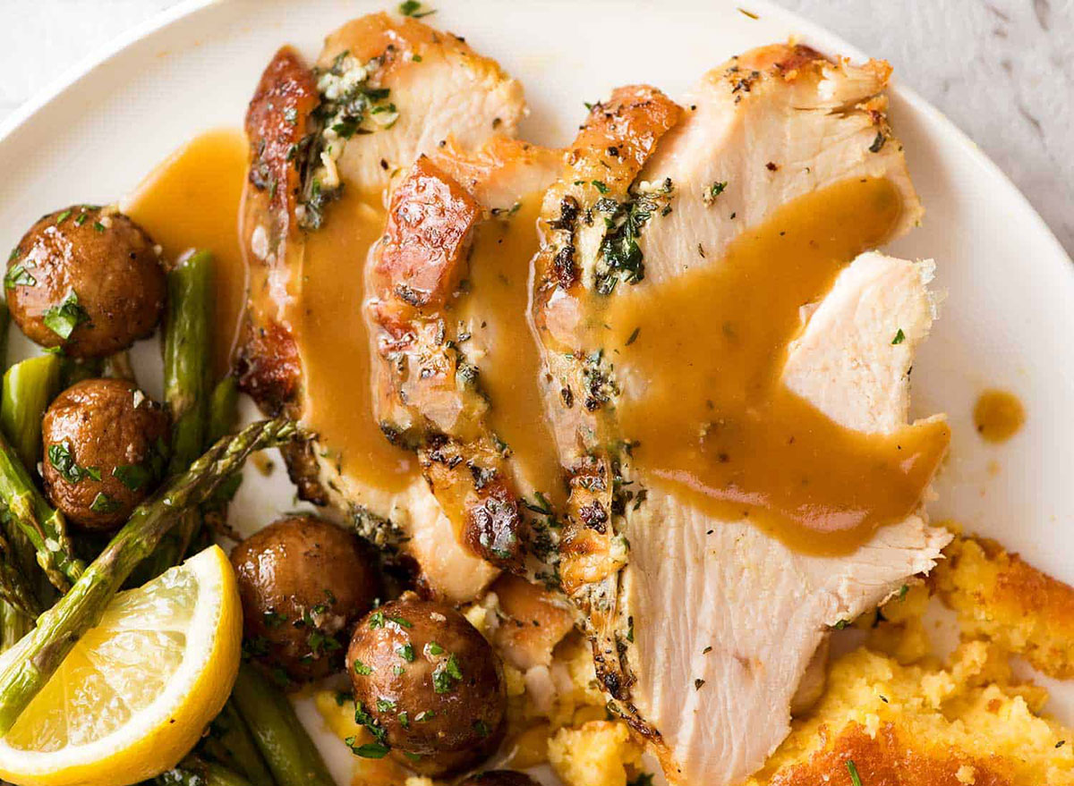 slow cooker turkey breast with gravy roasted mushrooms asparagus and lemon wedge