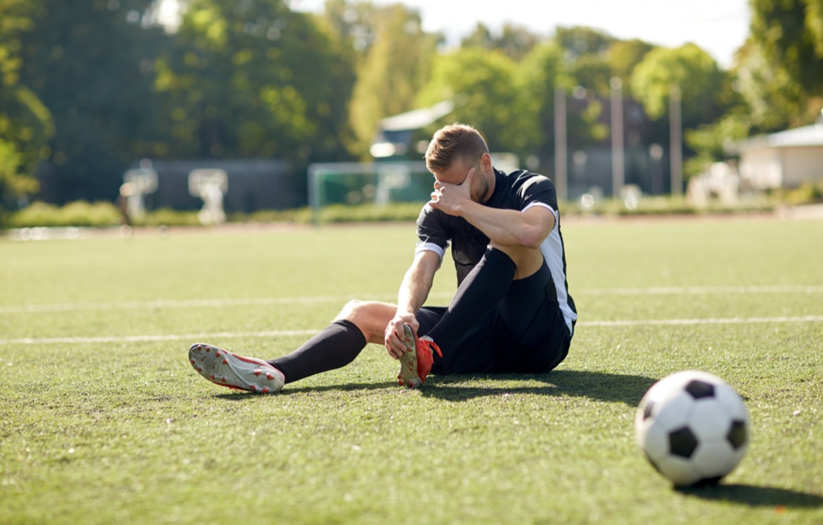injured soccer player with ball on field