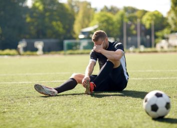 injured soccer player with ball on field