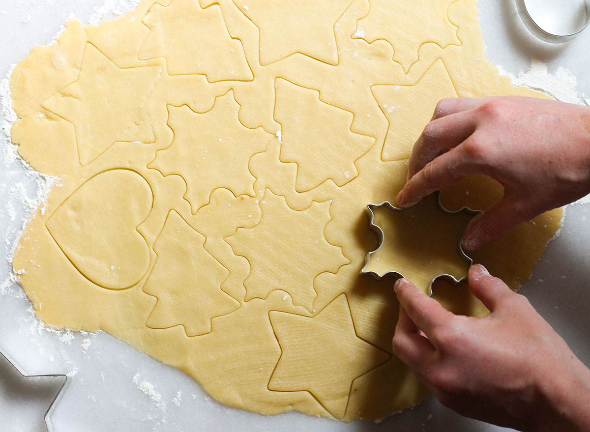 cutting sugar cookie shapes on a marble counter