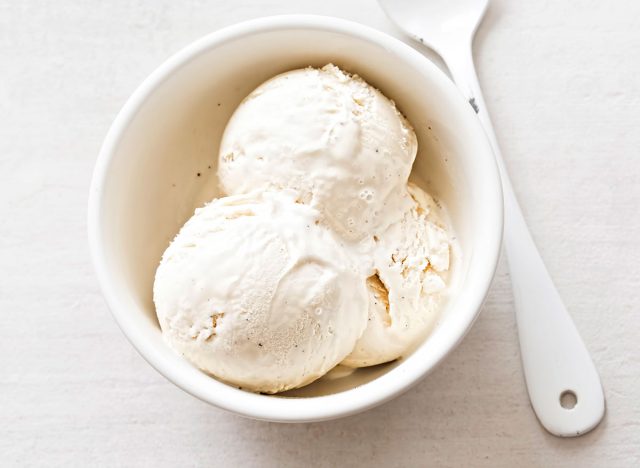 Ванильное мороженое в белой тарелке с ложкой