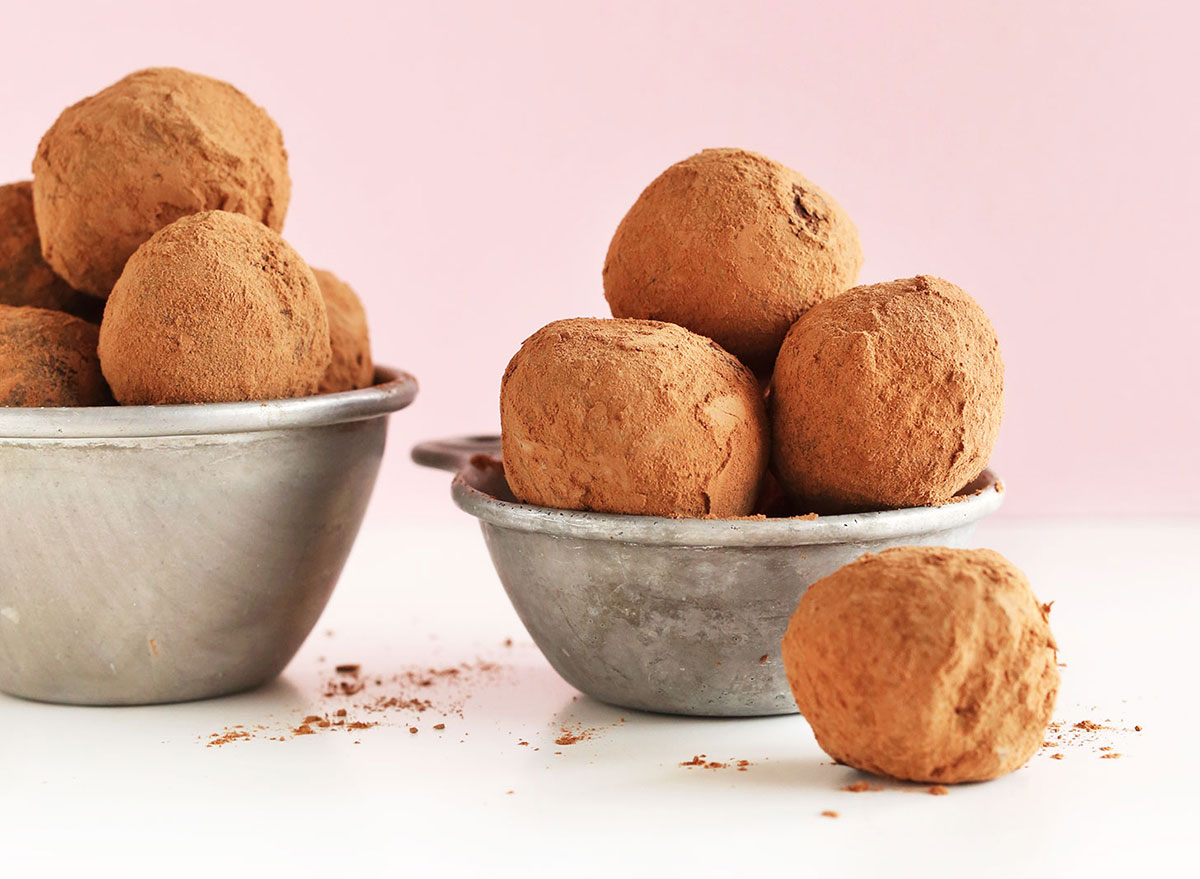 vegan dark chocolate truffles in metal serving bowls dusted with cocoa powder