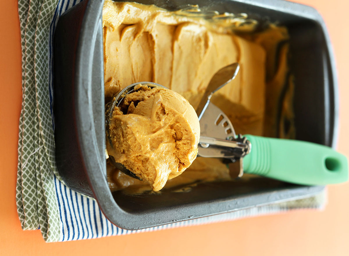 vegan pumpkin ice cream in metal pan with ice cream scoop