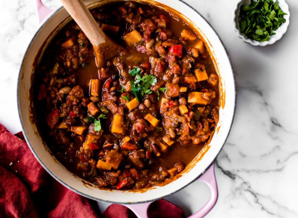 vegetarian pumpkin chili in pink pot on marble table