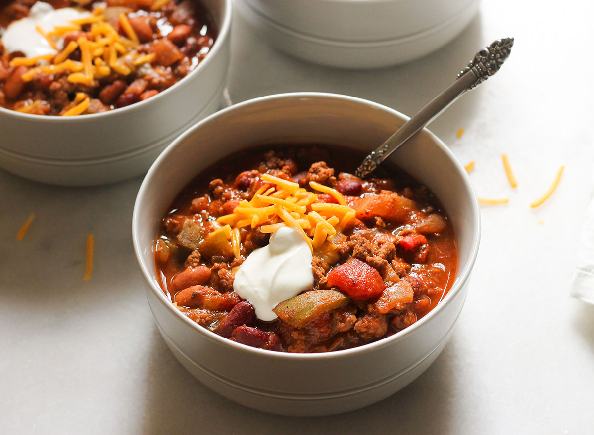 close up bowl of copycat wendy's chili with shredded cheese and sour cream