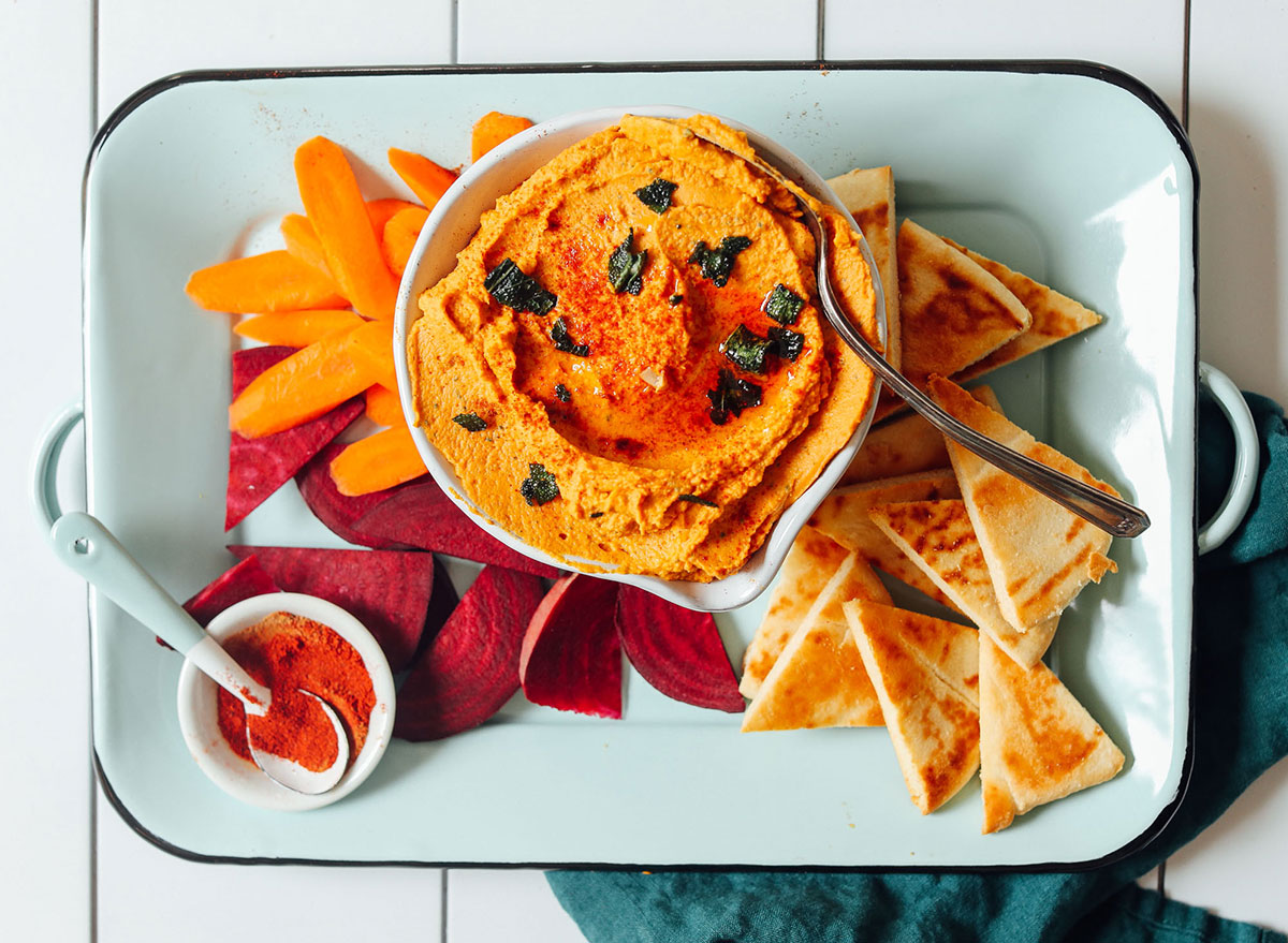 white bean pumpkin hummus with pita slices and bell peppers