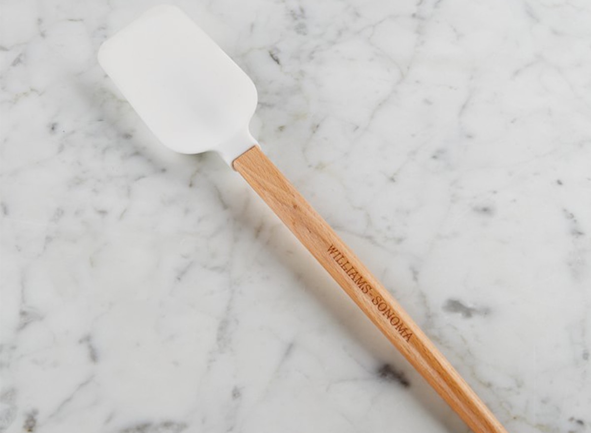 wood handled and white silicone spatula on gray marble background