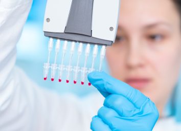 Woman technician with multipipette in genetic laboratory PCR research