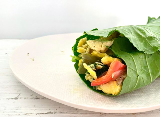 Whole30 breakfast burrito wrapped in cabbage greens on a white plate