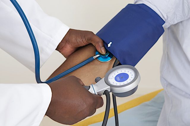 Doctor Measuring Patients Blood Pressure With Stethoscope