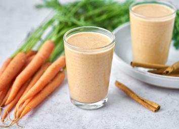 carrot cake smoothie in two glasses with carrots and cinnamon