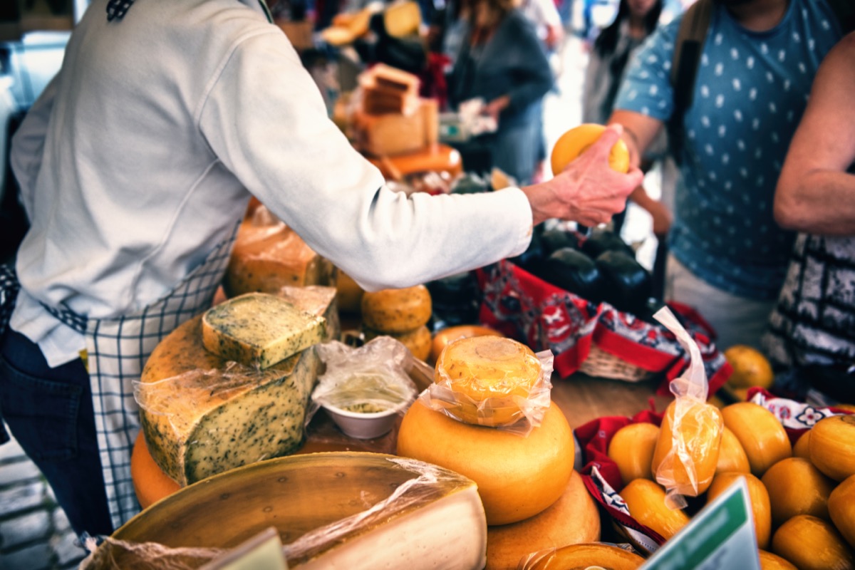 man serving cheese in a cheese shop