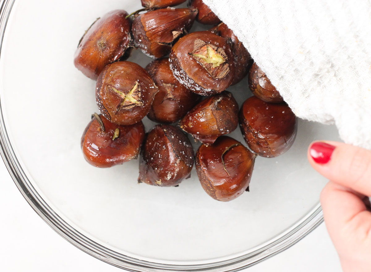 covering a bowl of roasted chestnuts with a towel to steam